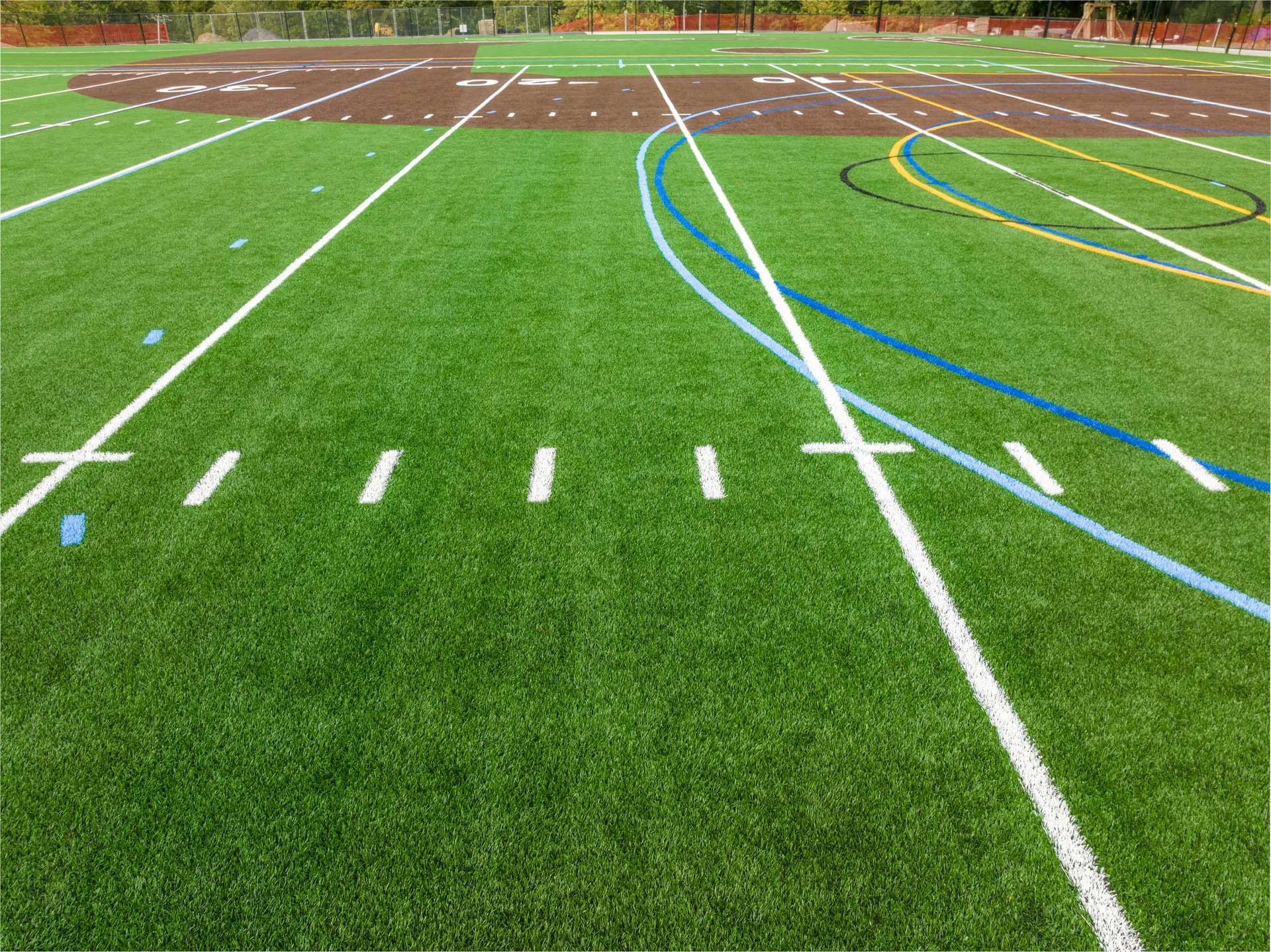 New synthetic turf field with football and baseball with lines and graphics.